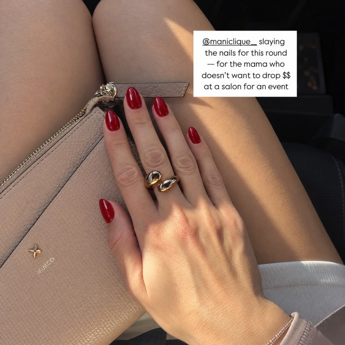 Burgundy manicure over handbag